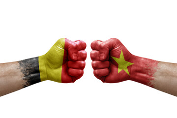 Two hands punch to each others on white background. Country flags painted fists, conflict crisis concept between belgium and vietnam