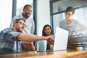 Working together to get the task done. Shot of businesspeople working together in the office.