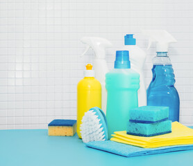 Set of cleaners and detergents, cleaning accessories, blue background with tiles. Concept spring regular cleaning