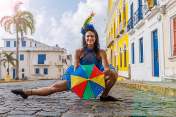 Beautiful Latin dancer dressed up for Carnival on the streets of Olinda. Frevo Recife. Brazil colors. Historical city. - obrazy, fototapety, plakaty