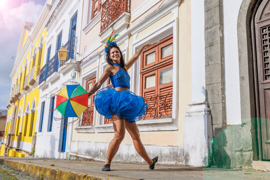 Beautiful Latin dancer dressed up for Carnival on the streets of Olinda. Frevo Recife. Brazil colors. Historical city.