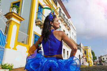 Beautiful Latin dancer dressed up for Carnival on the streets of Olinda. Frevo Recife. Brazil colors. Historical city.