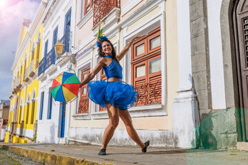 Beautiful Latin dancer dressed up for Carnival on the streets of Olinda. Frevo Recife. Brazil colors. Historical city. - obrazy, fototapety, plakaty