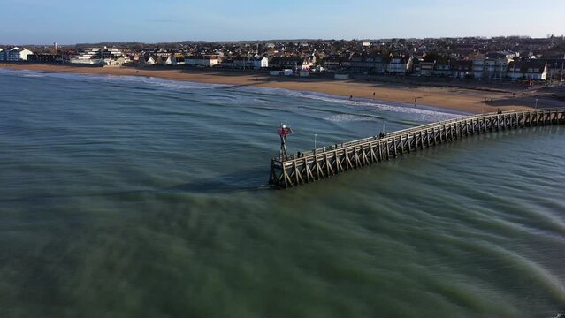 drone shot of the pier of courseulles-sur-mer in normandy with a view on the city from the ocean
