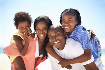 Our parents are so strong. An african-american family enjoying a day at the beach together.
