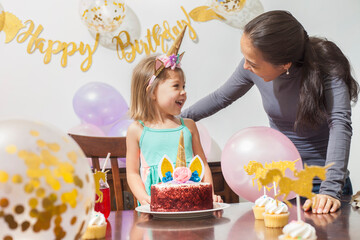 Mother and Daughter celebrating a birthday party with unicorn decorations