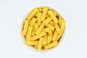 Raw Tortiglioni pasta, in a white bowl, isolated on a white background 