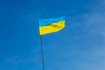Ukrainian flag flies against blue sky background. National flag of the state of Ukraine. Yellow-blue flag. Ukraine under attack. No war
