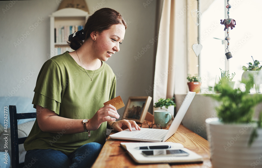 Canvas Prints I need to buy this. Cropped shot of an attractive young businesswoman sitting alone in her home office and using her laptop for online shopping.