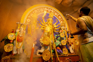 Kolkata, India - October 16, 2018 : Young Hindu Priest worshipping Goddess Durga with sacred lamps...