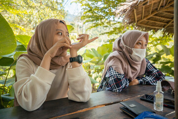 Two Indonesian girl smiling pose when she on the mountain restaurant. the photo perfect for family holidays background, nature pamphlet and advertising brochure.