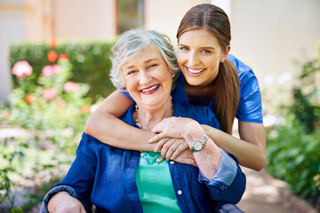 Making her stay as pleasant as possible. Shot of a resident and a nurse outside in the retirement...