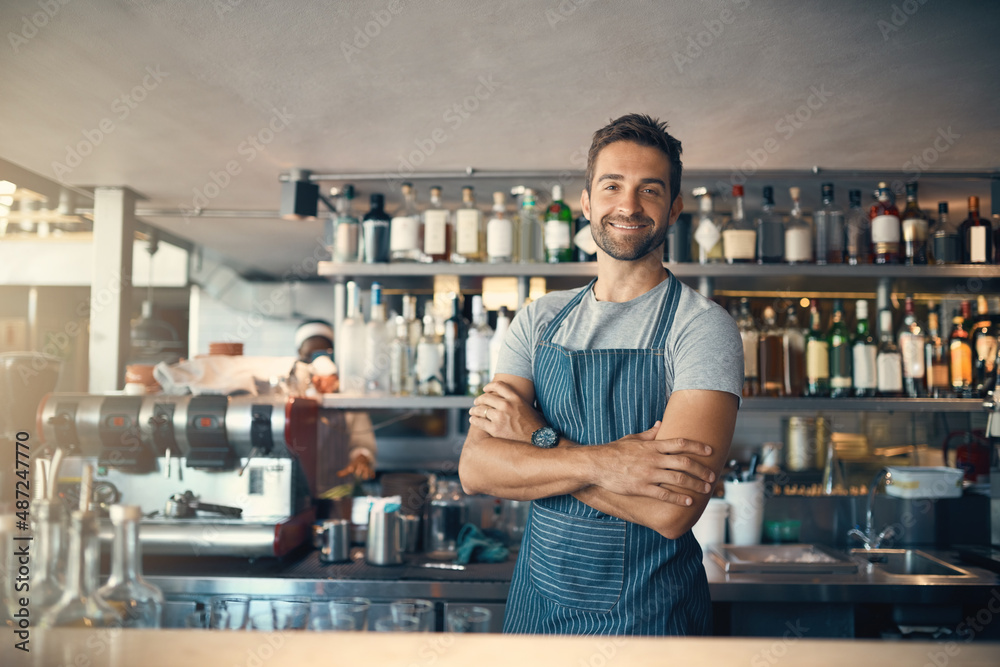 Poster theres a reason my customers keep coming back. portrait of a young man working behind a bar counter.