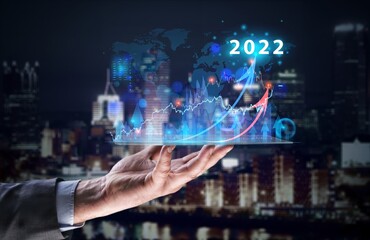 Businessman hand holding tablet showing graph economic growth target success. Plan business growth in year 2022 concept.
