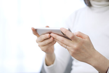 スマートフォンでゲームをするアジア人の女性	