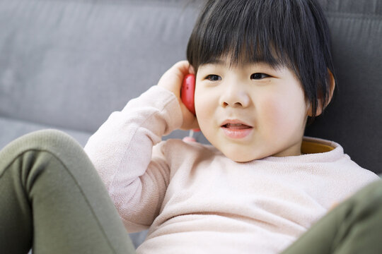電話で会話をするアジア人の幼児	
