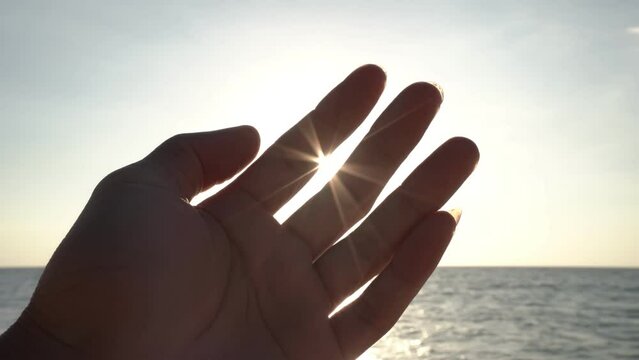 Hand of man strive to sun and Light flare deep sunset sky over sea Conceptual scene Faith in god dream a religion concept
