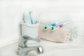 Toothbrush, toothpaste and face towel on basin in bathroom.