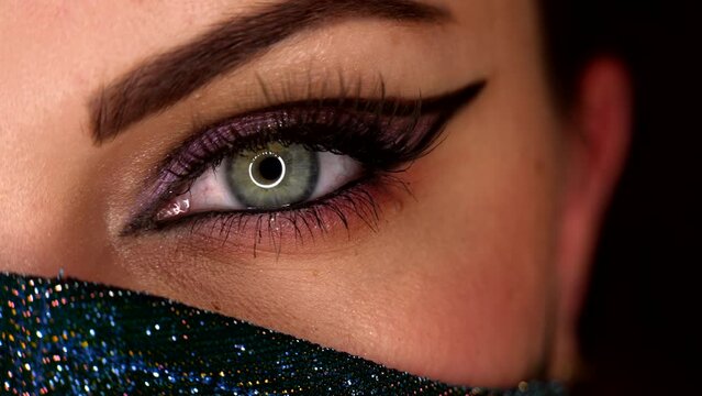 Lady in glitter protective mask. Macro. Glitter shadows and false lashes. Woman eye with fancy arrow make-up. Girl, green eye. Pandemic, covid-19 concept.