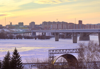Winter evening on the Ob. open stage on the river embankment, metro bridge