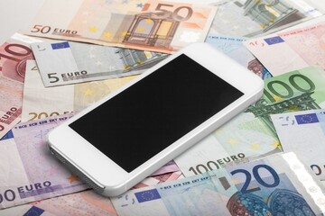 Blank screen smartphone on the pile of money