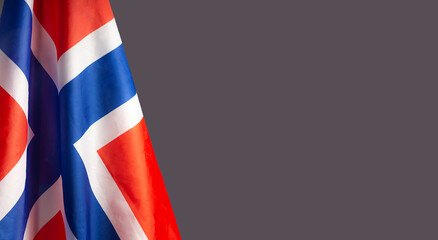 Close-up of the Norway flag is on the left side on a gray background