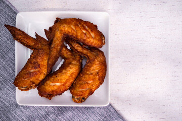 Grilled chicken wings on white plate. cooking roasted hot sauce. traditional food asian Thailand. dinner at restaurant. food for health concept.