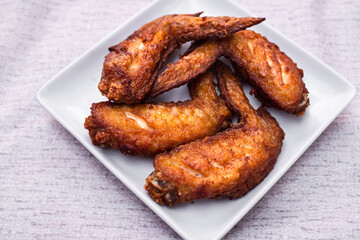 Grilled chicken wings on white plate. cooking roasted hot sauce. traditional food asian Thailand. dinner at restaurant. food for health concept.