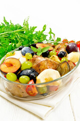 Chicken with fruits and tomatoes in pan on board