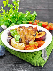 Chicken with fruits and tomatoes in plate on napkin