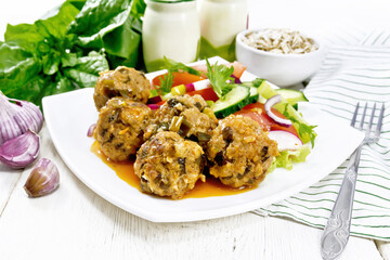 Meatballs with spinach and oatmeal on wooden board