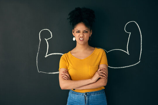 Sometimes Being Strong Is The Only Choice You Have. Shot Of A Woman Posing With A Chalk Illustration Of Flexing Muscles Against A Dark Background.