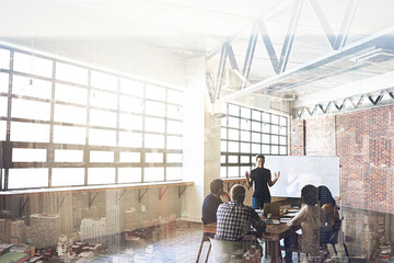 Readying themselves for great success. Multiple exposure shot of businesspeople having a meeting superimposed over a cityscape.