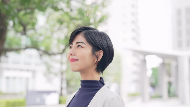 街中で空を見上げる女性