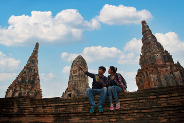 Traveler man and women with backpack Couple Tourist during visiting in Wat Chaiwatthanaram temple...
