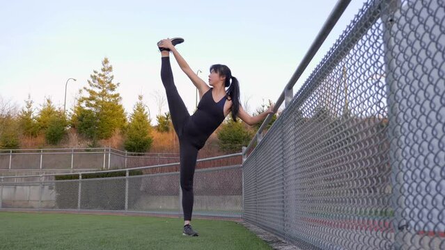 Fit woman performs standing splits morning stretching routine 
