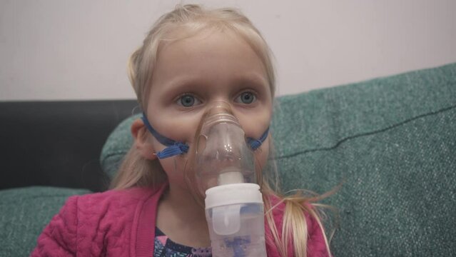 Girl Has Asthma or Pneumonia Disease and Need Nebulizations, Sick Girl Rest on Patient Bed and Has Inhalation Therapy by the Mask of Inhaler.