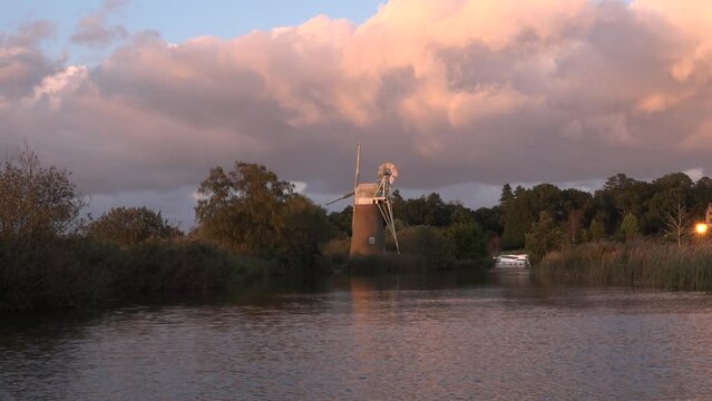 Norfolk windmills borads with holiday boats on water. Boating holiday and vacation place in England UK 4K