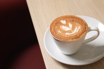 Cup of aromatic coffee on wooden table in cafe. Space for text