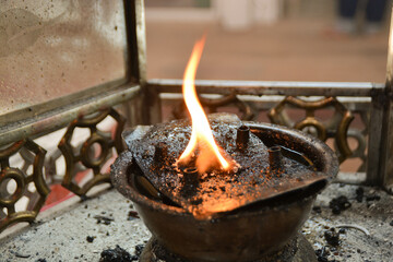 Flame of lamp at a temple for lighting candles and incense sticks.