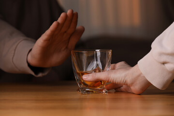 Obraz na płótnie Canvas Man refusing to drink whiskey indoors, closeup. Alcohol addiction treatment