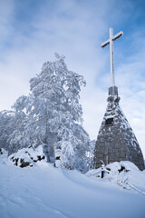 Fototapeta na wymiar Szczyt góry Ślęży zimą. Ślęża pokryta śniegiem. Kościół na Ślęży zimą pokryty śniegiem. Zimowy krajobraz Ślęży pokrytej śniegiem. Miś Ślężański zimą. Słowiańskie rzeźby kultowe na Ślęży