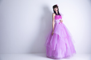 Obraz na płótnie Canvas ピンクのドレスを着てうつむく女性　dress