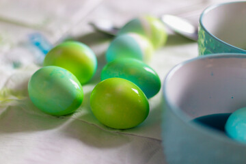 Easter eggs of blue and green color are painted at home independently on the eve of the Easter holiday