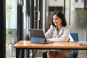 Obraz na płótnie Canvas Happy asian businesswoman reading good news on computer tablet.
