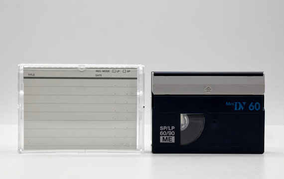 Vintage Mini DV video tape cassette with plastic cassette box on white background. Retro style technology from the 90s