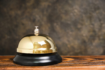 Gilded bell hotel service background concrete wall.Conceptual hotel, travel and recreation.