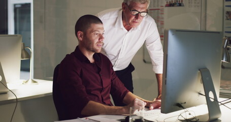 Fototapeta premium I could use your expertise on this. 4k video of two businessmen working late on a computer in an office.