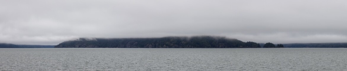 Echo Island in Harrison Lake during Cloudy and Foggy Winter Day. Panoramic Canadian Nature Landscape. Harrison Hot Springs, British Columbia, Canada. Background Panorama
