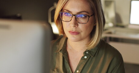 Focused on making success happen. 4k video of a young businesswoman working late on a computer in an office.